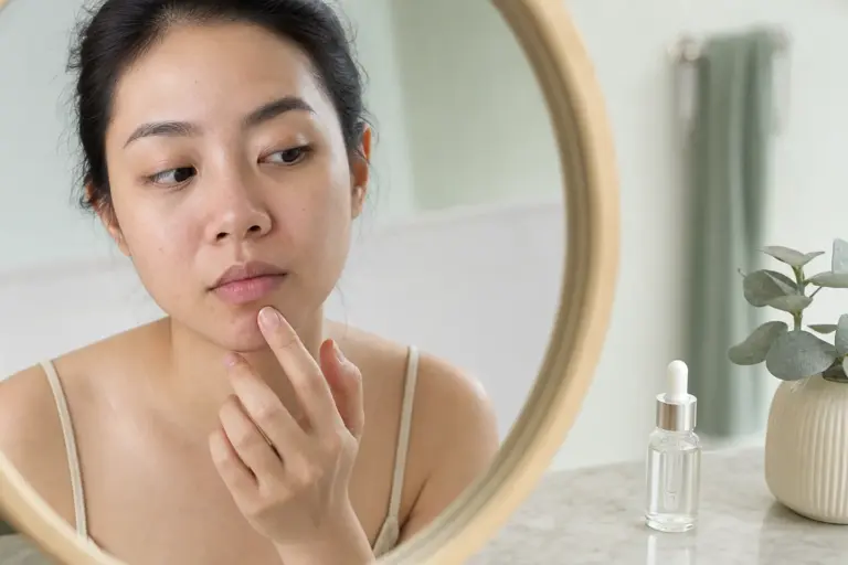Người phụ nữ quan sát vùng cằm dễ bít tắc trong gương